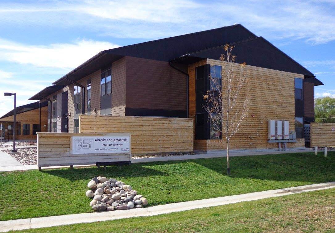side of building shows sign and green grass